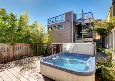 Small Wooden Walkout Deck With Hot Tub. House Exterior.